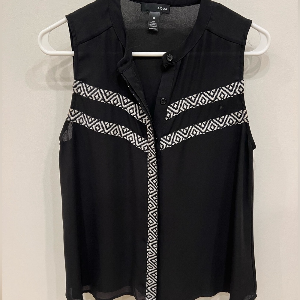 Aqua black sleeveless blouse with white embroidered pattern.